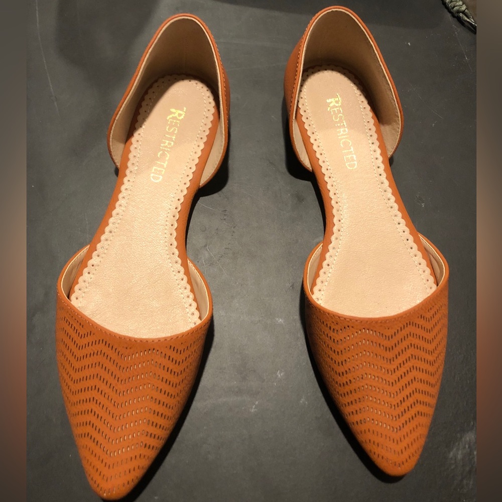 Restricted brown leather flats